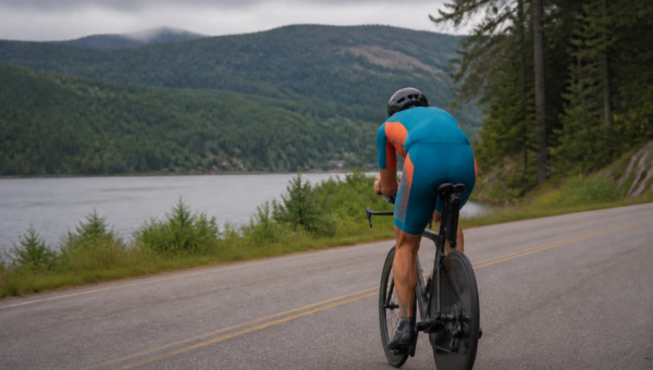 IRONMAN 70.3 Mont-Tremblant 2026 — triathlonista na rowerze nad jeziorem (ilustracja AI)