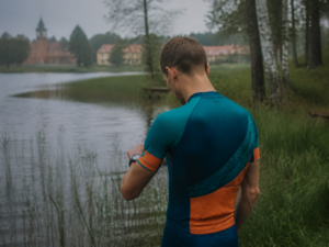 Suunto Race S – zegarek triathlonowy z ekranem AMOLED, triathlonista nad mazurskim jeziorem