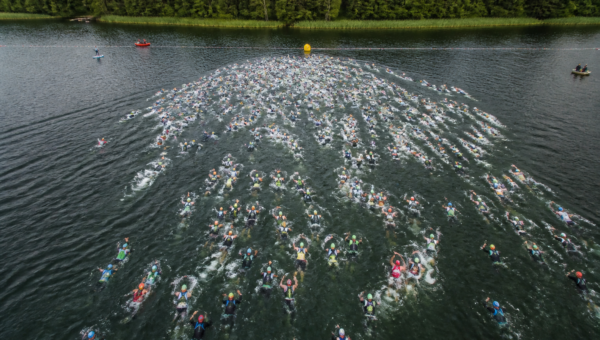Start w wodzie głębokiej — masowy start w triathlonie (ilustracja AI)