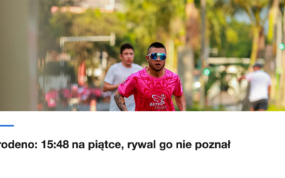 Zawodnik w różowej koszulce biegnie ulicą wśród palm
