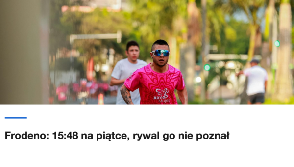 Zawodnik w różowej koszulce biegnie ulicą wśród palm
