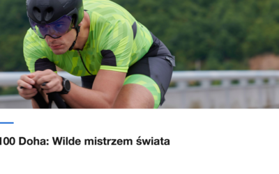Zawodnik w pozycji aerodynamicznej sprawdza zegarek na kierownicy