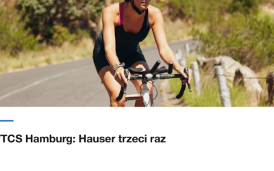Zawodniczka jedzie szosą wzdłuż zieleni