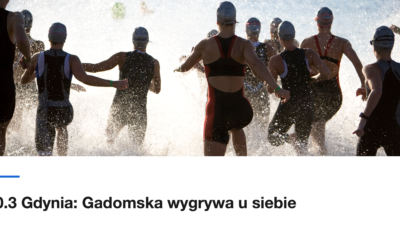 Grupa triathlonistów wbiega do wody na starcie zawodów