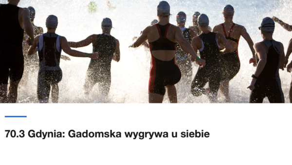 Grupa triathlonistów wbiega do wody na starcie zawodów