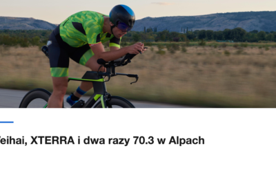 Triathlonista na rowerze czasowym na prostej drodze o zachodzie słońca