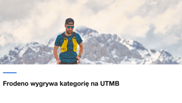 Biegacz górski na skalnym grzbiecie z zaśnieżonymi szczytami w tle