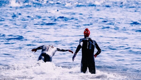Triathloniści wbiegają do wody otwartej