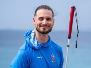 Rob Sears z białą laską na nabrzeżu w Nicei