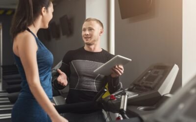 Trenerka z tabletem obok zawodnika na bieżni