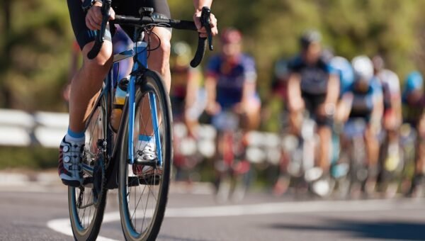 Grupa kolarzy na trasie rowerowej wyścigu triathlonowego