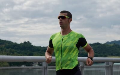 Triathlonista biegnie w stroju startowym po czesci rowerowej