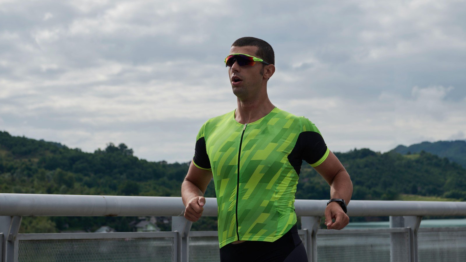 Triathlonista biegnie w stroju startowym po czesci rowerowej