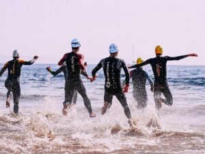 Zawodnicy wbiegajacy do wody na starcie triathlonu