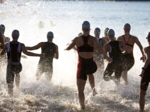 Triathlonisci wbiegajacy do wody na starcie
