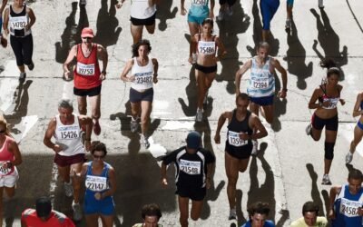 Peleton biegaczy z numerami startowymi na ulicy podczas maratonu