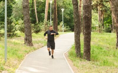 Biegacz sprawdzajacy zegarek sportowy na trasie w parku