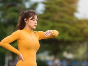 Biegaczka sprawdzajaca zegarek sportowy przed treningiem