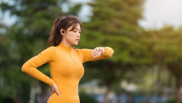 Biegaczka sprawdzajaca zegarek sportowy przed treningiem