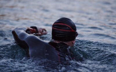 Plywak w piance triathlonowej w ciemnej wodzie